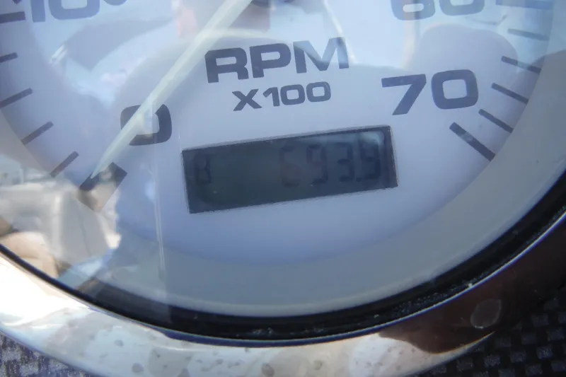 Slide: The Image of Close-up of a 2004 Sea Ray 180 Sport tachometer displaying 693.9 RPM. - 17