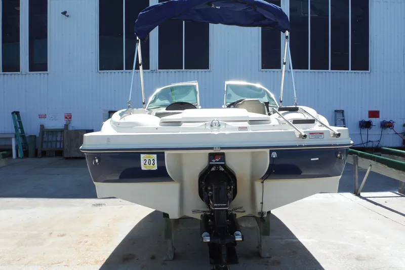 Slide: The Image of 2004 Sea Ray 180 Sport boat with blue canopy, docked outdoors. - 3
