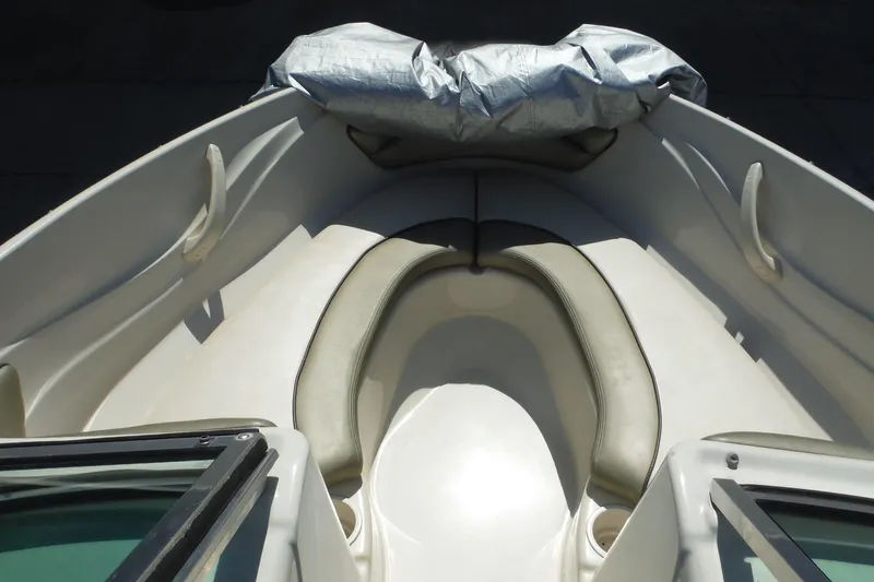 Slide: The Image of 2004 Sea Ray 180 Sport boat interior with cushioned seating and covered bow area. - 9