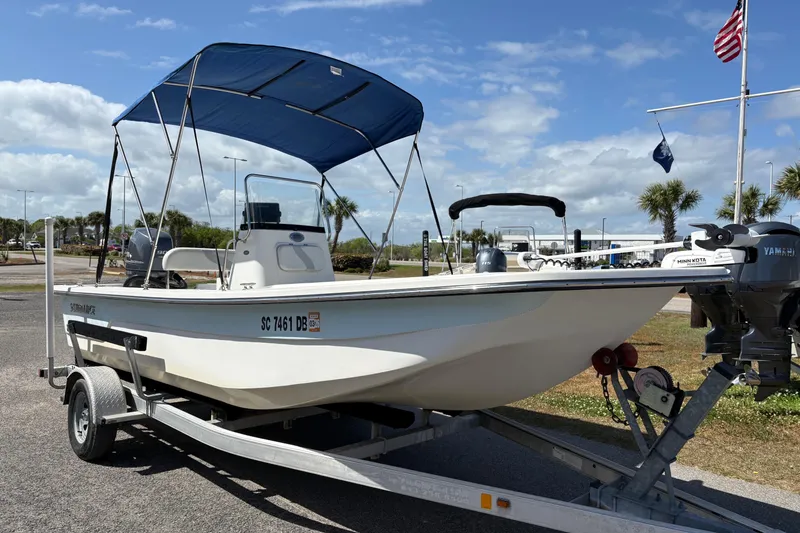 Slide: The Image of 2014 Sundance B20CCR boat on trailer with blue canopy, parked outdoors. - 5