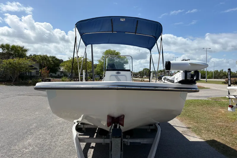 Slide: The Image of 2014 Sundance B20CCR boat with blue canopy on trailer, parked outdoors. - 6