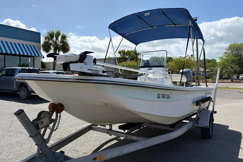 Slide: The Image of 2014 Sundance B20CCR boat with blue canopy on trailer, parked outdoors. - 7