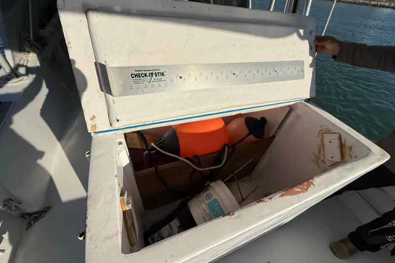 Slide: The Image of Open storage compartment on 1988 Stuart Angler 32 boat with various equipment inside. - 10