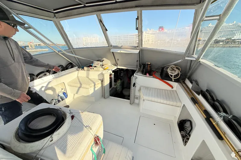 Slide: The Image of Interior of a 1988 Stuart Angler 32 boat with fishing gear and seating. - 11