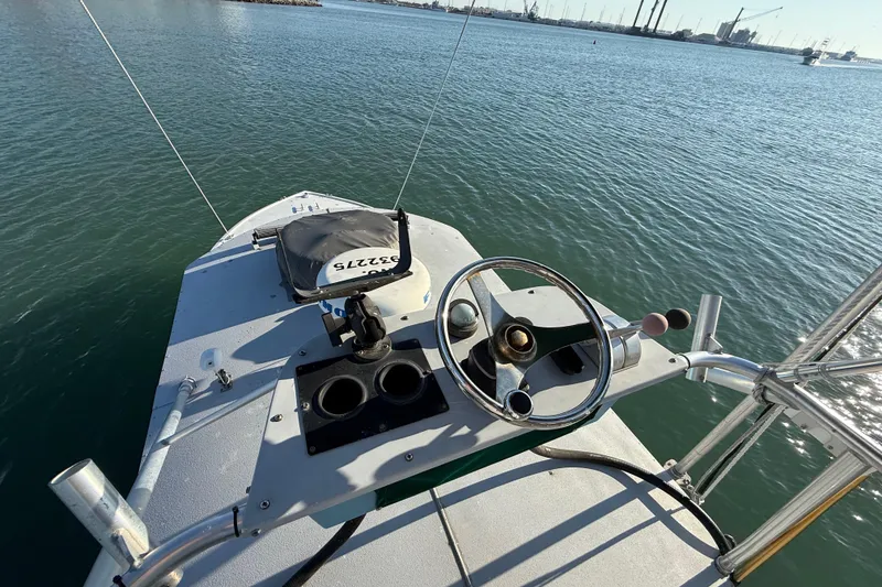 Slide: The Image of 1988 Stuart Angler 32 boat helm with steering wheel, controls, and ocean view. - 16