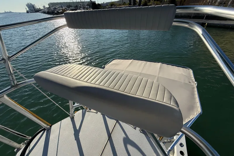 Slide: The Image of 1988 Stuart Angler 32 boat with cushioned seating, overlooking a serene waterfront. - 19