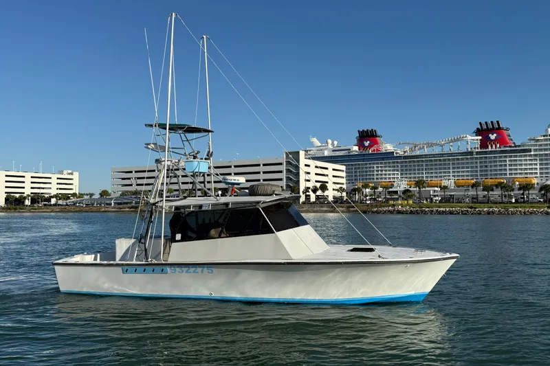 Slide: The Image of 1988 Stuart Angler 32 boat on water, with cruise ship and buildings in background. - 4