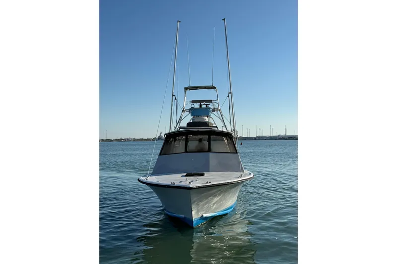 Slide: The Image of 1988 Stuart Angler 32 boat on calm water under clear blue sky. - 6