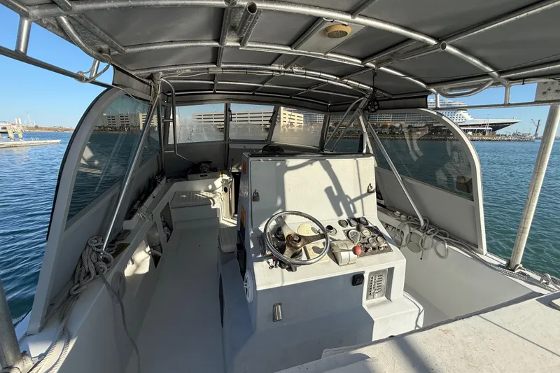 Slide: The Image of 1988 Stuart Angler 32 boat interior with steering wheel, docked in marina. - 9