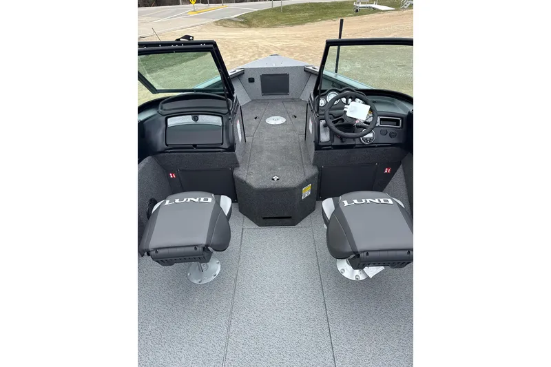 Slide: The Image of 2026 Lund 1875 Fisherman boat interior with dual seats and steering console. - 2