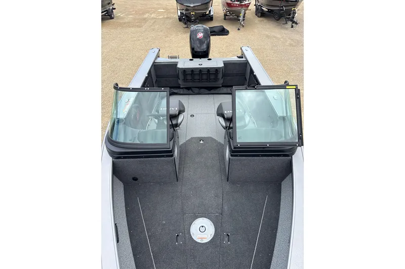 Slide: The Image of 2026 Lund 1875 Fisherman boat interior with dual windshields and seating, parked on land. - 4