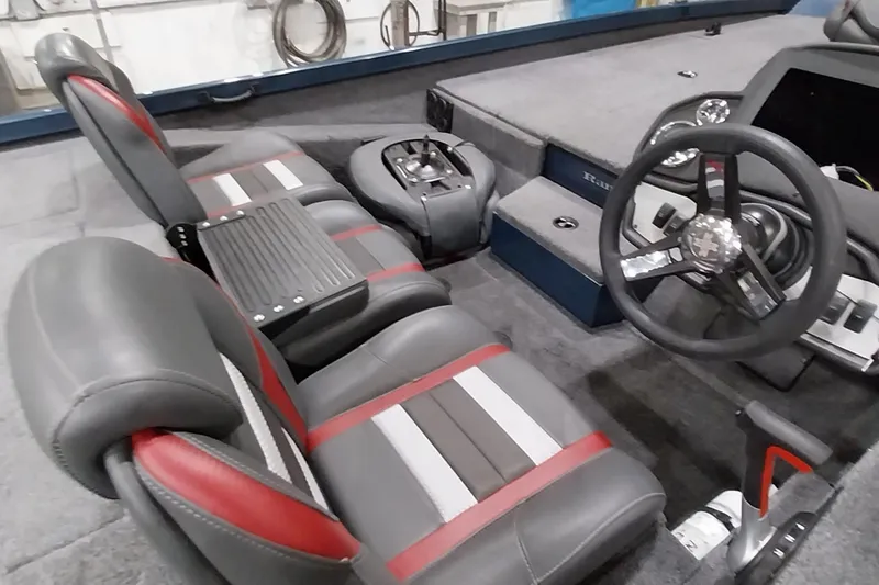 Slide: The Image of 2024 Ranger RT198P boat interior with gray and red seating, steering wheel, and dashboard. - 19