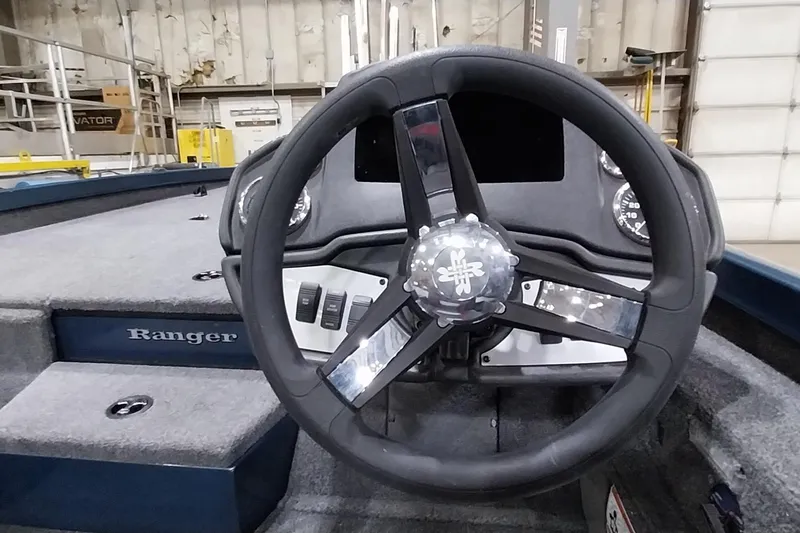 Slide: The Image of 2024 Ranger RT198P boat steering wheel and dashboard in a factory setting. - 21