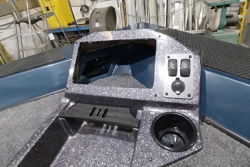 Slide: The Image of 2024 Ranger RT198P boat console with switches and cup holder in a workshop setting. - 22