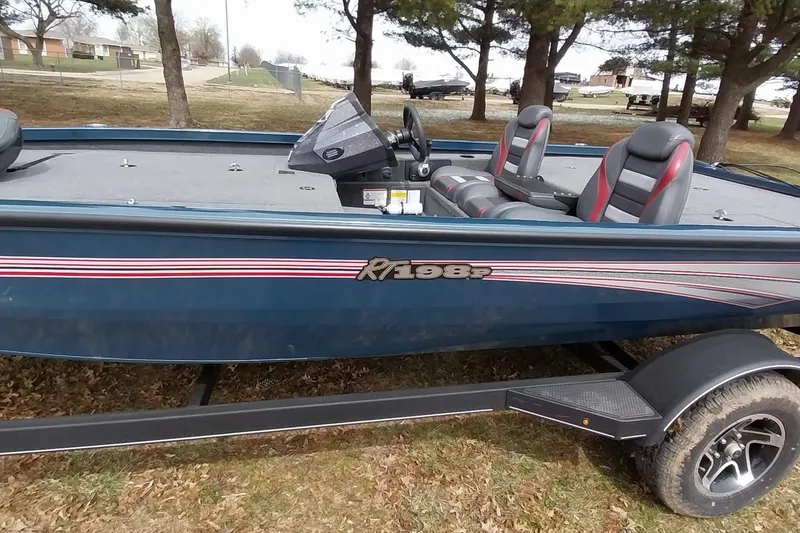 Slide: The Image of 2024 Ranger RT198P fishing boat on trailer, parked outdoors under trees. - 30