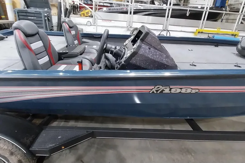 Slide: The Image of 2024 Ranger RT198P boat with dual seats and steering console in a showroom. - 4