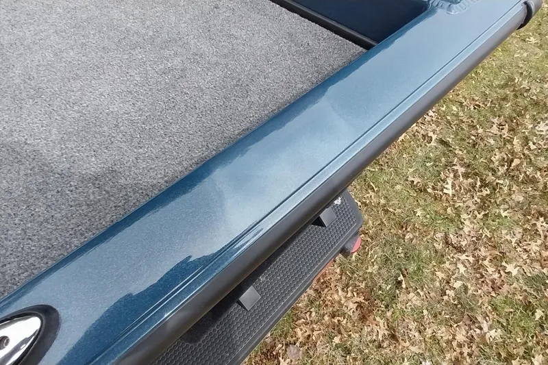 Slide: The Image of 2024 Ranger RT198P boat deck with blue finish and gray carpet, on grassy background. - 46