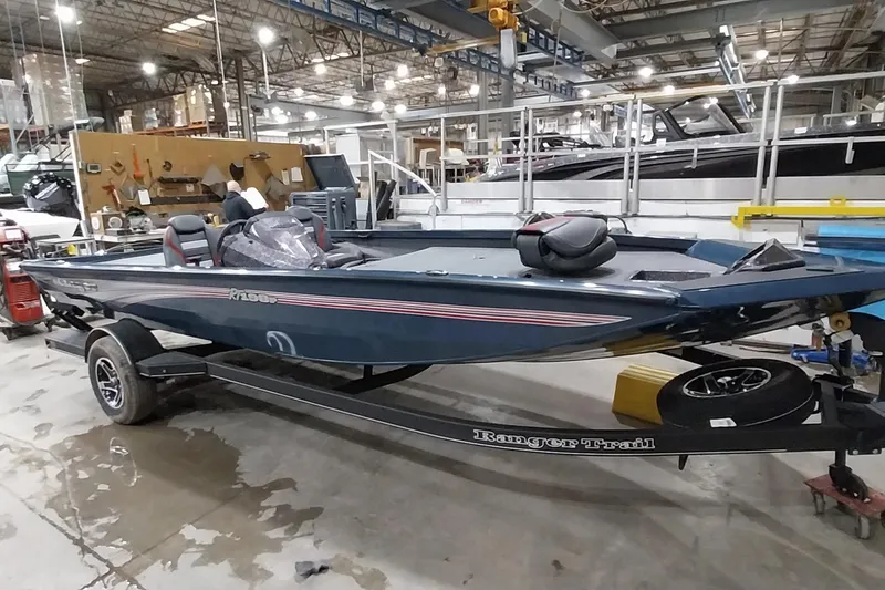 Slide: The Image of 2024 Ranger RT198P boat in a factory setting, showcasing sleek design and trailer. - 6