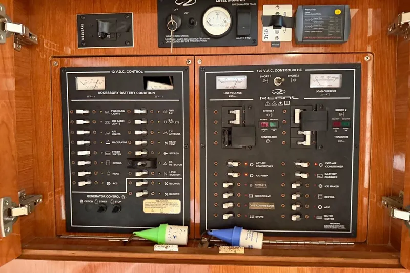 Slide: The Image of Electrical control panel of a 2005 Regal Commodore 3860 boat, featuring switches and gauges. - 18