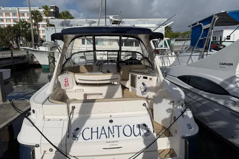 Slide: The Image of 2005 Regal Commodore 3860 yacht docked at marina, rear view with name "CHANTOU". - 3