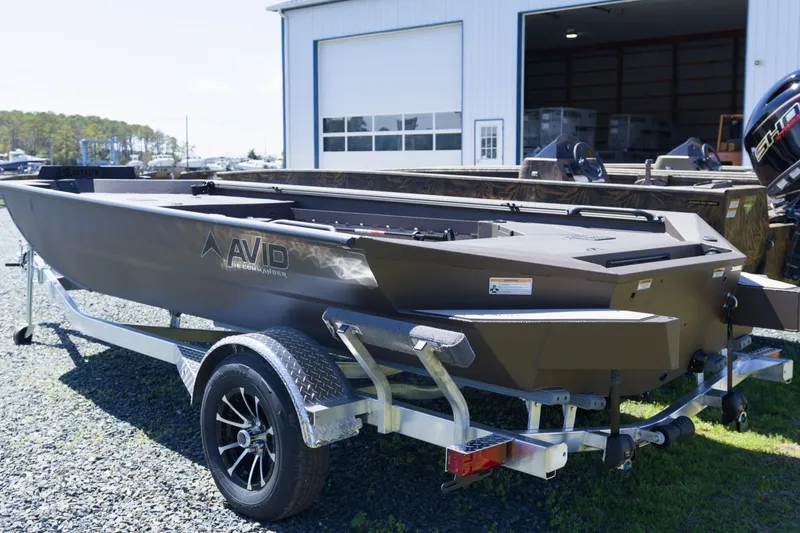 Slide: The Image of 2026 Avid 18 Commander boat on trailer outside a storage facility. - 2