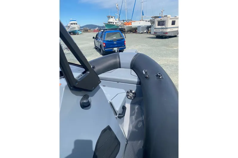 Slide: The Image of 2024 Sealegs 7.5 boat on land, near vehicles and other boats. - 13