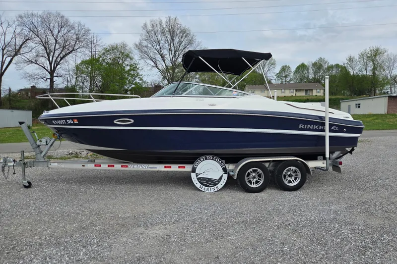 The Image of 2016 Rinker 236 Captiva Cuddy boat on trailer, parked outdoors. - 0
