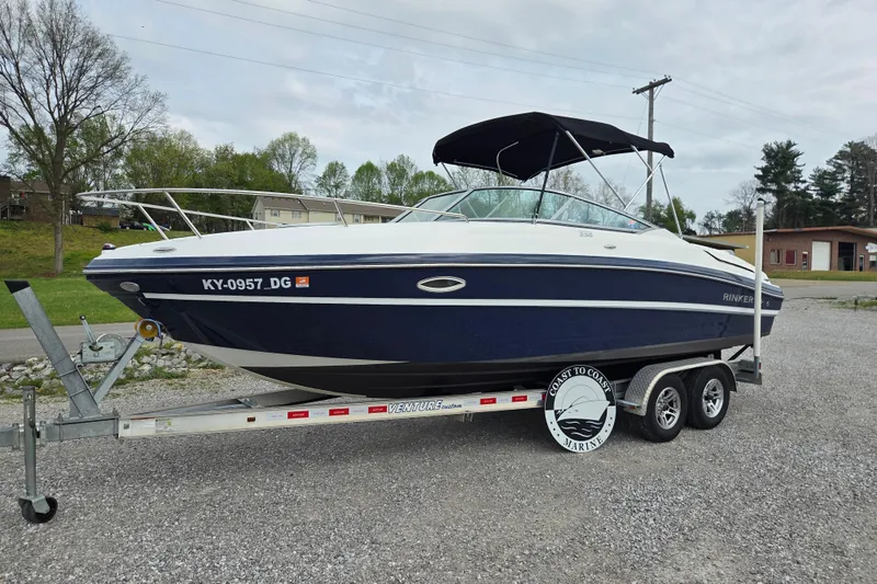 Slide: The Image of 2016 Rinker 236 Captiva Cuddy boat on trailer, parked outdoors. - 1