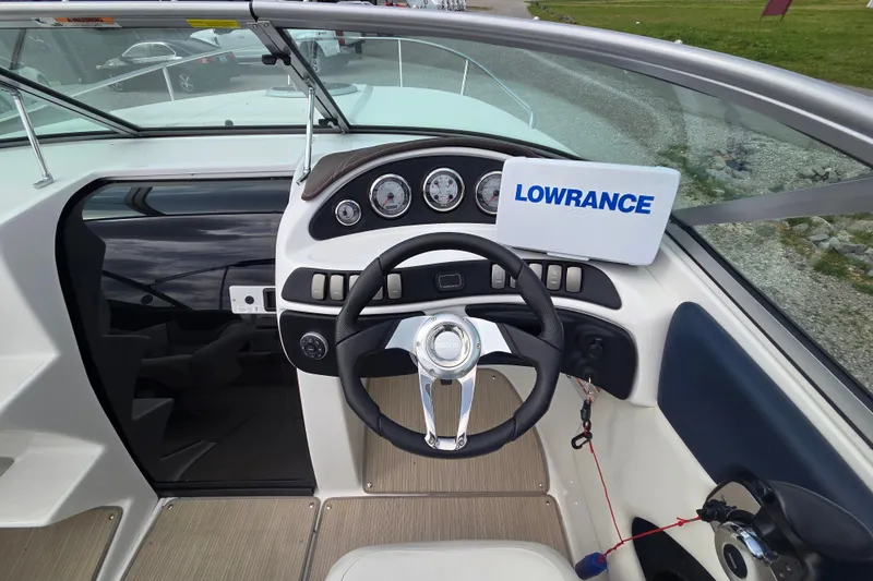 Slide: The Image of 2016 Rinker 236 Captiva Cuddy boat dashboard with steering wheel and Lowrance navigation system. - 11