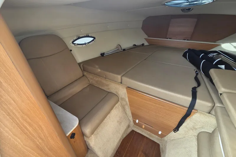 Slide: The Image of 2016 Rinker 236 Captiva Cuddy cabin interior with seating and storage. - 15