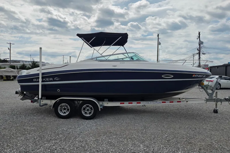 Slide: The Image of 2016 Rinker 236 Captiva Cuddy boat on trailer, parked outdoors under cloudy sky. - 3