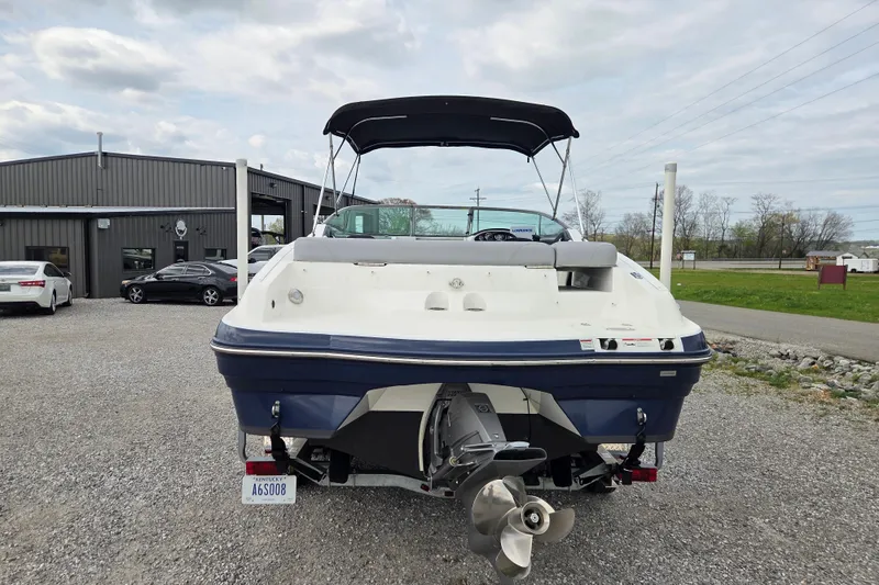 Slide: The Image of 2016 Rinker 236 Captiva Cuddy boat, rear view, parked outdoors near a building. - 4