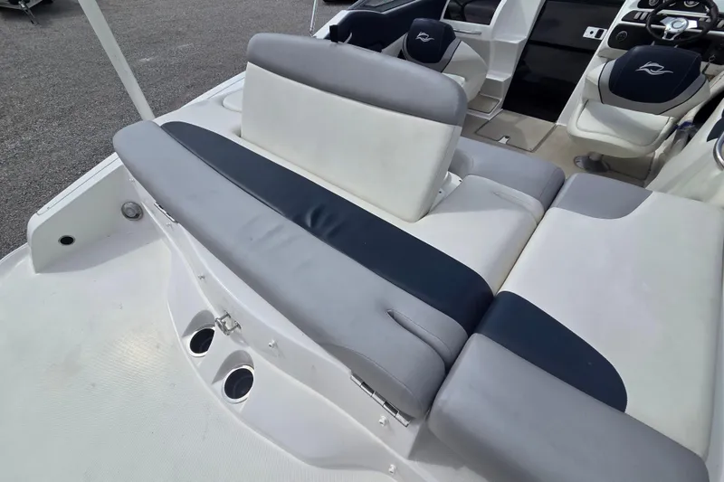Slide: The Image of 2016 Rinker 236 Captiva Cuddy boat interior with cushioned seating and steering area. - 6
