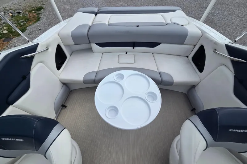 Slide: The Image of 2016 Rinker 236 Captiva Cuddy boat interior with seating and a round table. - 7