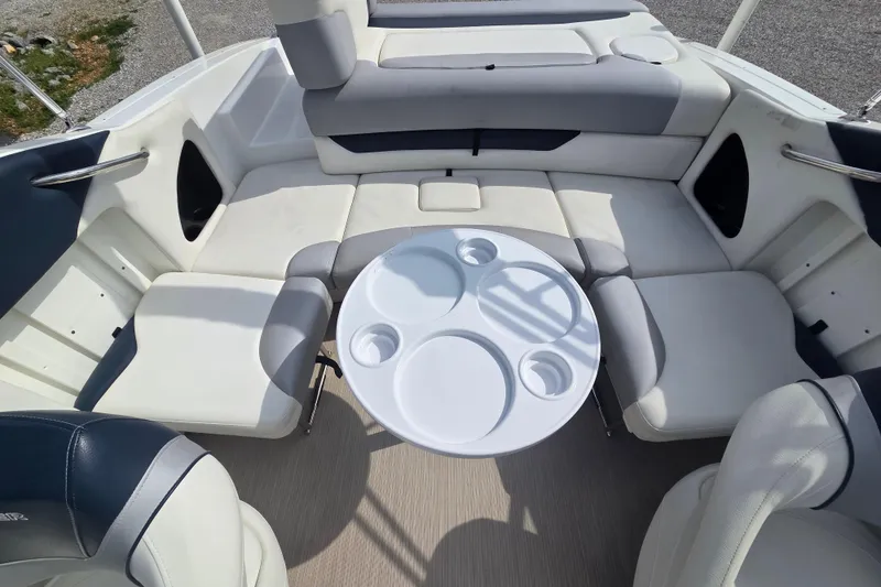 Slide: The Image of 2016 Rinker 236 Captiva Cuddy boat interior with cushioned seating and round table. - 8