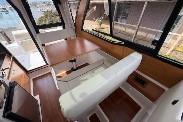 Slide: The Image of Interior of 2026 Cutwater C-248 Coupe with seating and table, marina view. - 6