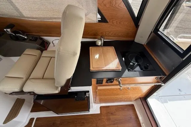 Slide: The Image of Interior of 2026 Cutwater C-248 Coupe featuring helm seat and compact kitchen area. - 7