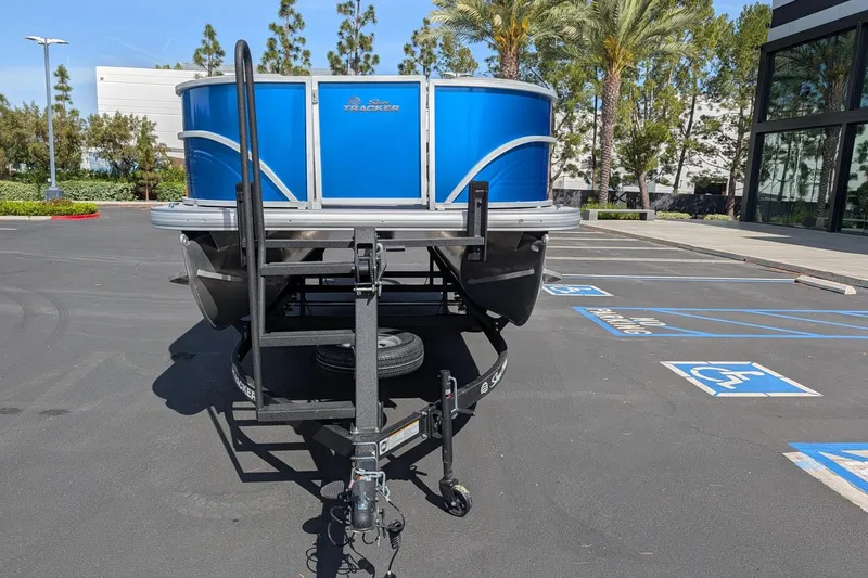 Slide: The Image of 2026 Sun Tracker Party Barge 16 DLX pontoon boat on trailer in parking lot. - 2