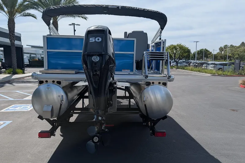 Slide: The Image of 2026 Sun Tracker Party Barge 16 DLX pontoon boat with Mercury 50 engine, parked outdoors. - 3