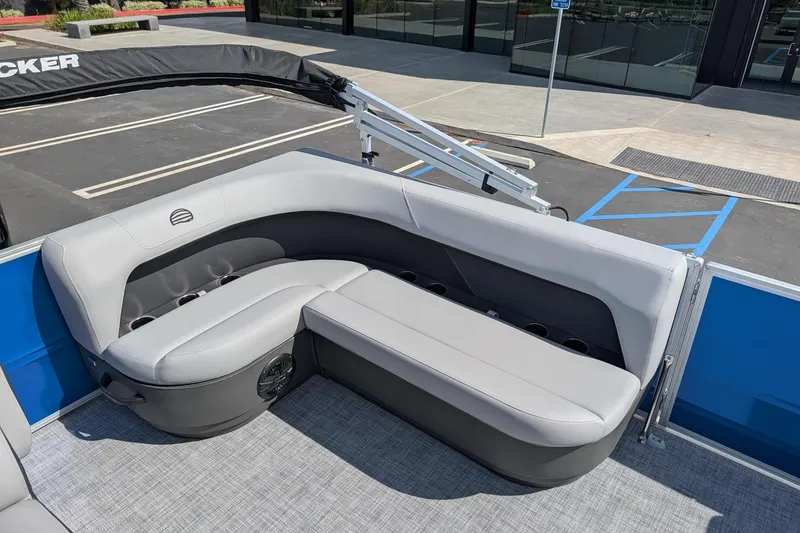 Slide: The Image of 2026 Sun Tracker Party Barge 16 DLX interior with gray seating and cup holders. - 7