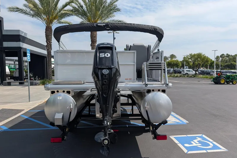 Slide: The Image of 2026 Sun Tracker Party Barge 16 DLX pontoon boat with Mercury 50 engine in parking lot. - 2