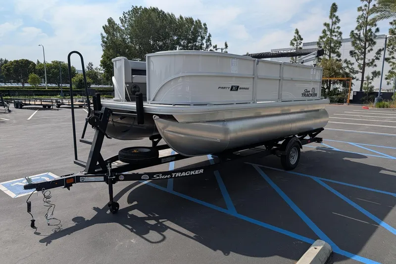 Slide: The Image of 2026 Sun Tracker Party Barge 16 DLX pontoon boat on trailer in parking lot. - 4