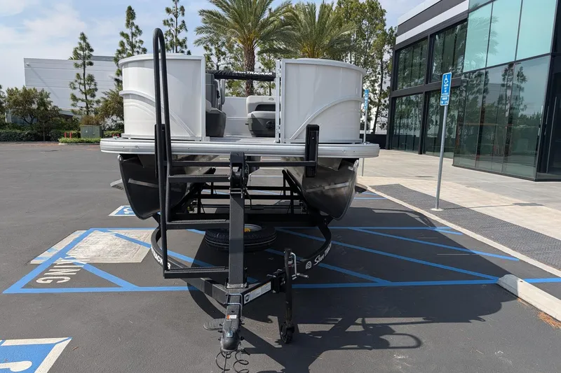 Slide: The Image of 2026 Sun Tracker Party Barge 16 DLX pontoon boat on trailer in parking lot. - 5