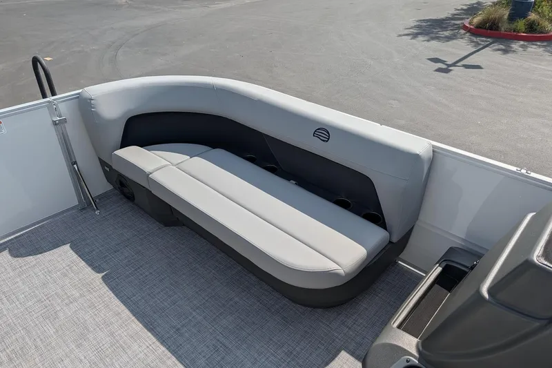 Slide: The Image of 2026 Sun Tracker Party Barge 16 DLX interior seating with gray upholstery and cup holders. - 6