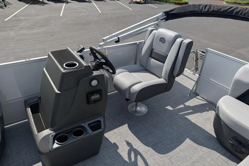 Slide: The Image of 2026 Sun Tracker Party Barge 16 DLX interior with captain's chair and steering console. - 7