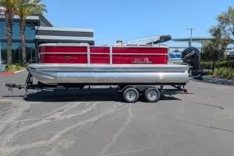 The Image of 2026 Sun Tracker Party Barge 20 DLX pontoon boat on trailer, parked outdoors. - 0