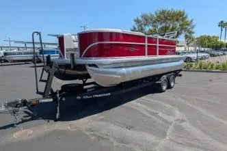 Slide: The Image of 2026 Sun Tracker Party Barge 20 DLX pontoon boat on trailer in parking lot. - 2