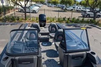 Slide: The Image of 2026 Tracker Targa V-18 WT boat interior with seating and windshield, parked outdoors. - 10