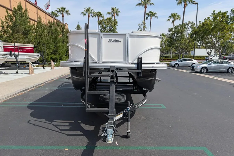 Slide: The Image of 2026 Sun Tracker Party Barge 20 DLX pontoon boat on trailer in parking lot. - 2