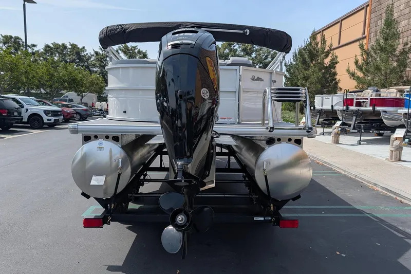 Slide: The Image of 2026 Sun Tracker Party Barge 20 DLX pontoon boat with outboard motor, parked outdoors. - 5